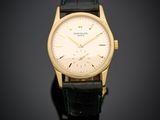 une montre-bracelet plaquée or, avec un cadran blanc et un bracelet en cuir noir