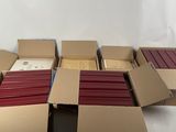 several boxes of red and white colored pencils sitting on top of a table