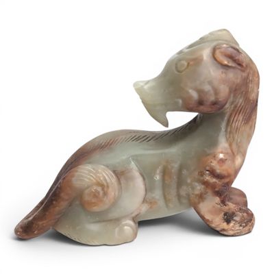 une figurine représentant un chien assis sur une surface blanche