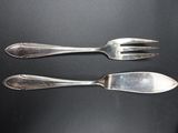 two forks and a spoon on a black table