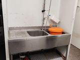 a sink in the corner of a room with a faucet in it