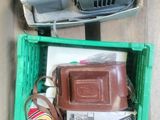 a green box filled with assorted items sitting on the floor