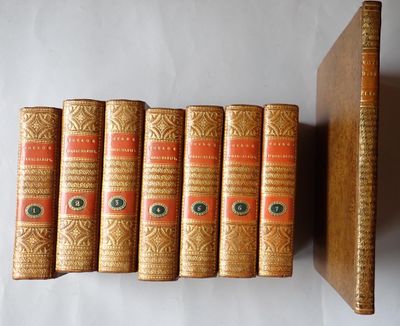 six old books are lined up on a shelf next to a book case