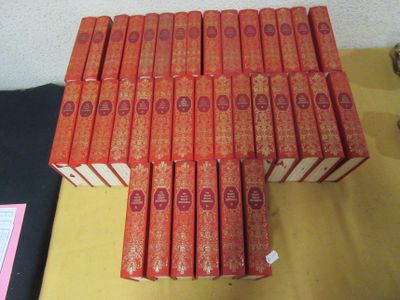 de nombreux livres rouges empilés les uns sur les autres sur une table