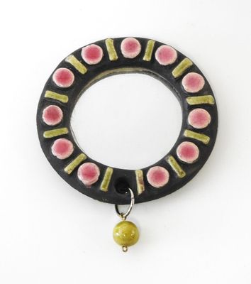 une photo d'une bague noire et rose ornée d'une perle jaune