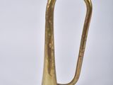 an old brass trumpet sitting on top of a white surface