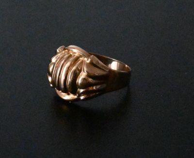 a gold ring that is sitting on a black surface
