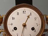 a gold clock with a bird on top of it