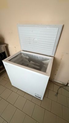 un congélateur coffre blanc posé dans le coin d'une pièce