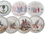 several plates with different designs of people on them on a white surface