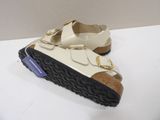 pair of children ' s white and black sandals on a white surface