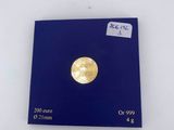 a gold coin on a blue card on a white surface