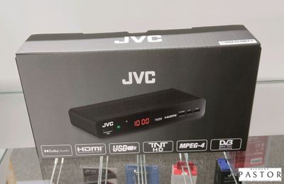 un boîtier sur lequel repose une télécommande, posé sur une table