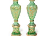 une paire de vases verts ornés de motifs dorés sur fond blanc