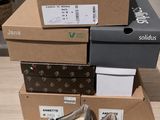 trois boîtes de chaussures sont empilées les unes sur les autres sur une table