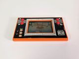 an orange and black gameboy sitting on top of a white table