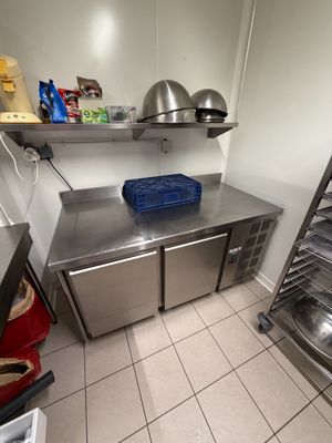 a kitchen with a stainless steel counter top and shelves