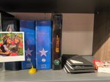 a shelf with books, a picture frame, and a rubber duck on it