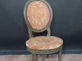 an old chair with a red and gold upholstered seat