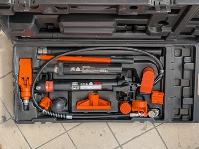 vue de dessus d'une boîte à outils contenant des outils, posée sur un sol carrelé