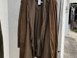 two jackets hanging on a clothes rack in a room