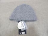 grey knitted beanie with a tag on top of it