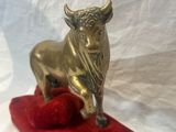 statue of a bull on a red cushion on a white background