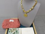 a necklace, wallet, and other items sitting on a tray