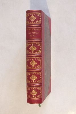 un livre rouge avec des inscriptions dorées sur une couverture blanche