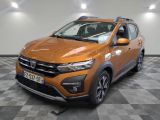 La voiture orange est garée sur un sol à damier dans le garage.