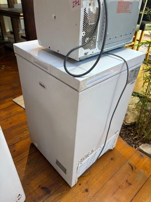 deux micro-ondes empilés l'un sur l'autre sur un plancher en bois