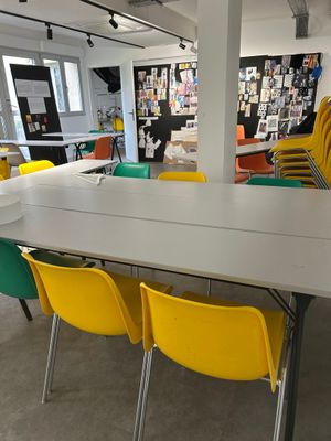 yellow and green chairs and a white table in a large room