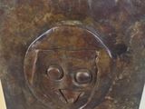 a metal sculpture of a face on the side of a wall