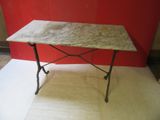 a marble top table with iron legs and a marble top
