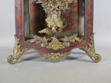 a red and gold clock with a bird on top of it
