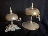 deux bougeoirs anciens en laiton et une cloche sur fond noir