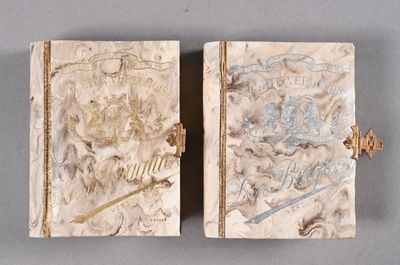 une paire de couvertures de livres anciennes ornées de motifs décoratifs sur un fond gris