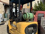 a yellow forklift truck parked in front of a house