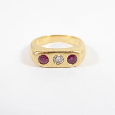 a yellow gold ring with three ruby stones and a diamond