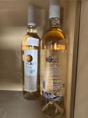 two bottles of wine sitting next to each other on a shelf