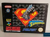 une image représentant une boîte sur laquelle est posée une figurine de Superman