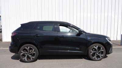 Le SUV noir est garé devant un immeuble blanc.