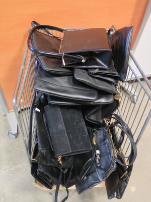 une pile de sacs en cuir noir posée sur un caddie