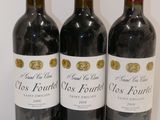trois bouteilles de vin rouge sont alignées sur une table