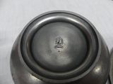 a close up of a silver vase on a table