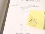 un livre sur lequel est collé un autocollant jaune, posé sur une table
