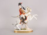 a figurine of a man riding a horse with a sword
