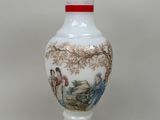 un vase blanc avec un tableau posé sur une table