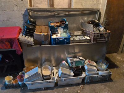 a lot of dirty dishes and containers on the floor