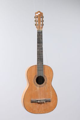 an image of a guitar hanging from a string on a wall